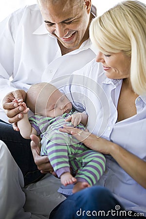 Loving parents holding baby sound asleep in arms