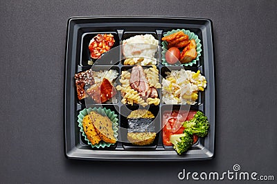 Lunch box with sushi and rolls