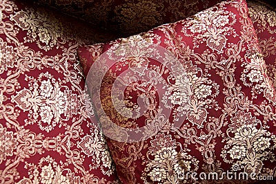 Luxurious cushions on bed in gold brocade