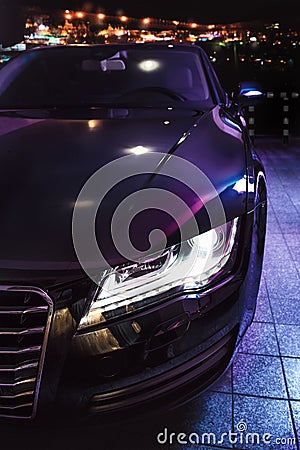 Luxury car at the parking in front of the night city