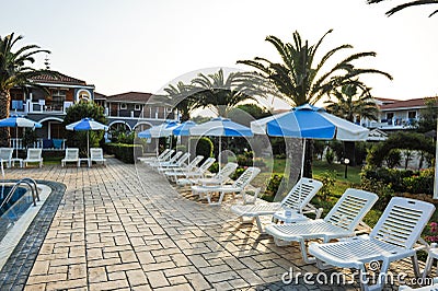 Sun beds at swimming pool in a tropical hotel in Greece