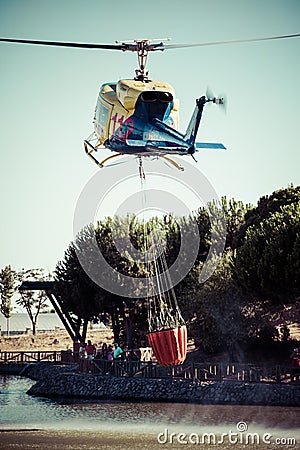 MADRID, SPAIN - AUGUST 3 : Fire rescue heavy helicopter with water bucket, goes to a fire in Madrid on August 3, 2013, Spain.