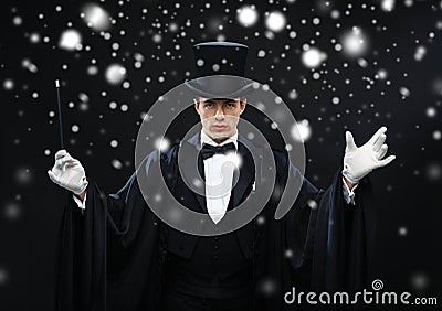 Magician in top hat with magic wand showing trick