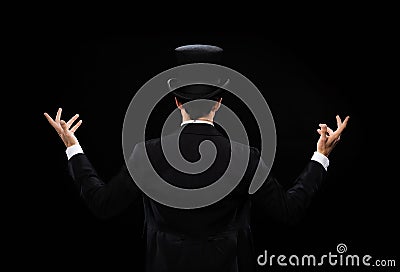 Magician in top hat showing trick from the back