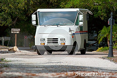 Mail delivery truck with mailboxes in background