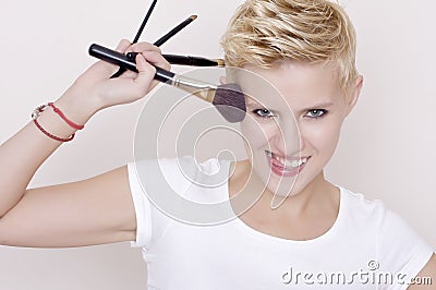 Make-up artist holding brushes