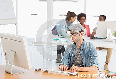 Male artist using computer with colleagues in at office