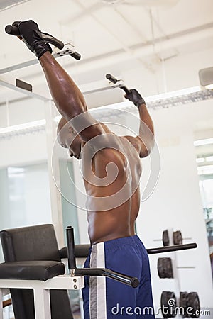 Male body builder doing pull ups at the gym