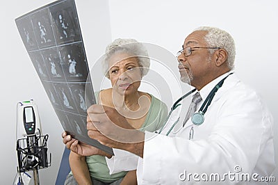 Male Doctor Explaining X-Ray Report To Patient