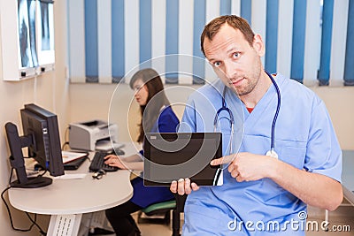 Male doctor using a tablet computer in a hospital.