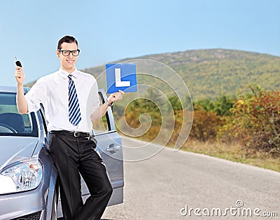 Male driver holding l sign on an open road