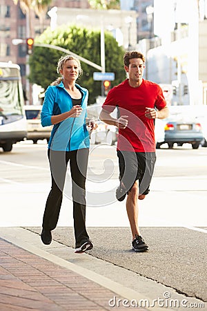 Male And Female Runners On Urban Street