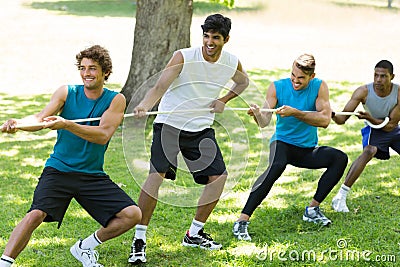 Male friends playing tug of war