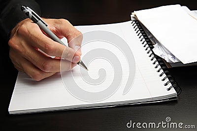 Male hand writing on a notepad