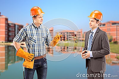 Male manual worker having a conversation with architect, constru