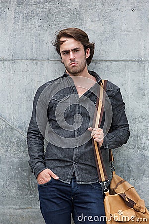 Male model posing with leather travel bag