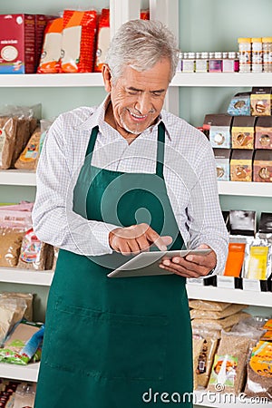 Male Owner Using Tablet In Supermarket
