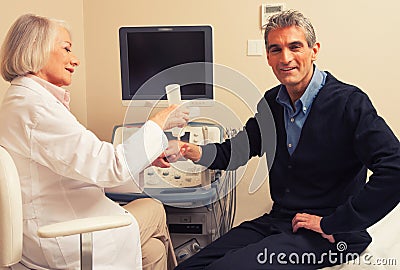Male patient undergoing wrist ultrasound with female doctor