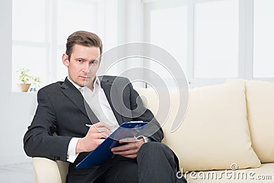Male psychologist being ready to take notes