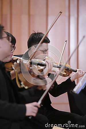 Male students playing violin