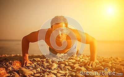 Man athlete trains, practicing, on the beach