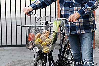 Man and bicycle basket full of groceries