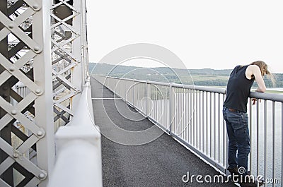 Man on bridge contemplating suicide