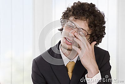 Man in business suit massaging his eye to relieve