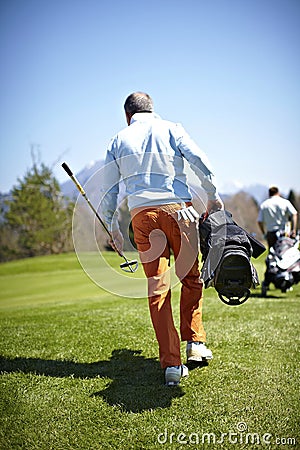 Man carrying a bag with golf clubs