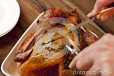 Man carving a delicious brown roast chicken