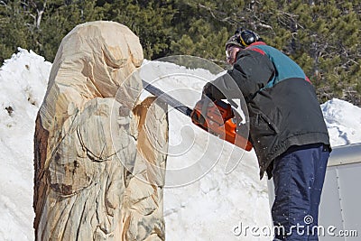 Man Carving face on Huge Bear from Log with Chainsaw