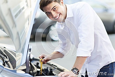 Man checking oil level in car
