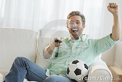 Man Cheering While Watching Soccer Match At Home