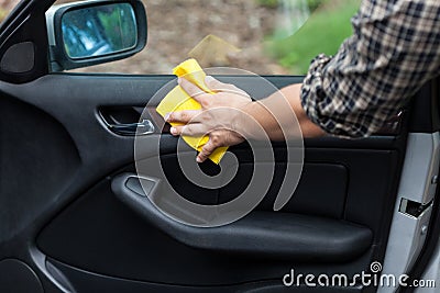 Man cleaning door in a car