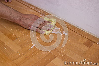 Man cleaning floor after painting wall