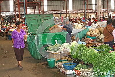 Man collects garbage at the vegetables market,Laos