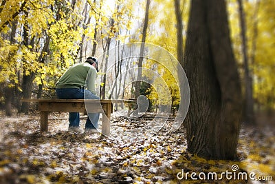 Man Contemplates Life Issues On a Bench In Fall Fo
