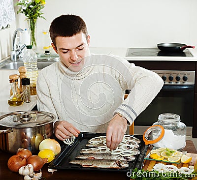 Man cooking raw fish and onion