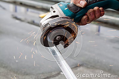 Man cutting a metal bar with a circular saw