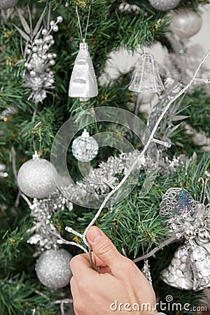 Man Decorating Christmas Tree With Fairy Lights