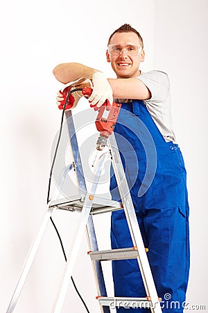 Man with drill standing on ladder