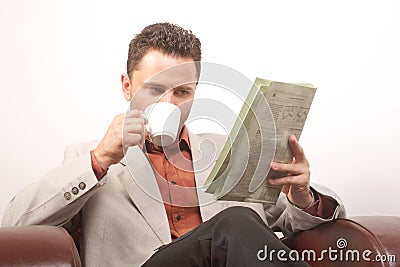 Man drinking coffee,reading newspaper