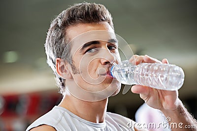 Man Drinking Water From Bottle At Health Club