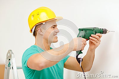 Man with electric drill making hole in wall