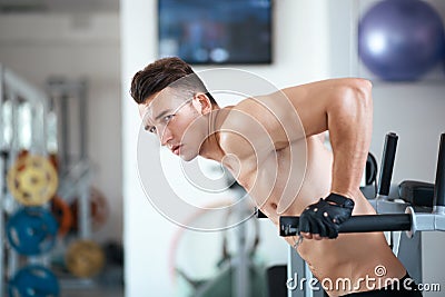 Man exercising in trainer for pectoral muscles