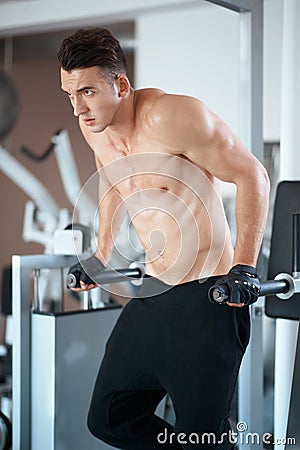 Man exercising in trainer for pectoral muscles