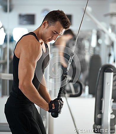 Man exercising in trainer for triceps muscles