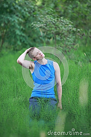 Man with eyes closed exercising on meadow