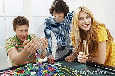 Man With Friends Playing With Chips At Roulette Table