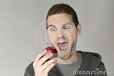 Man with funny face looking at an apple